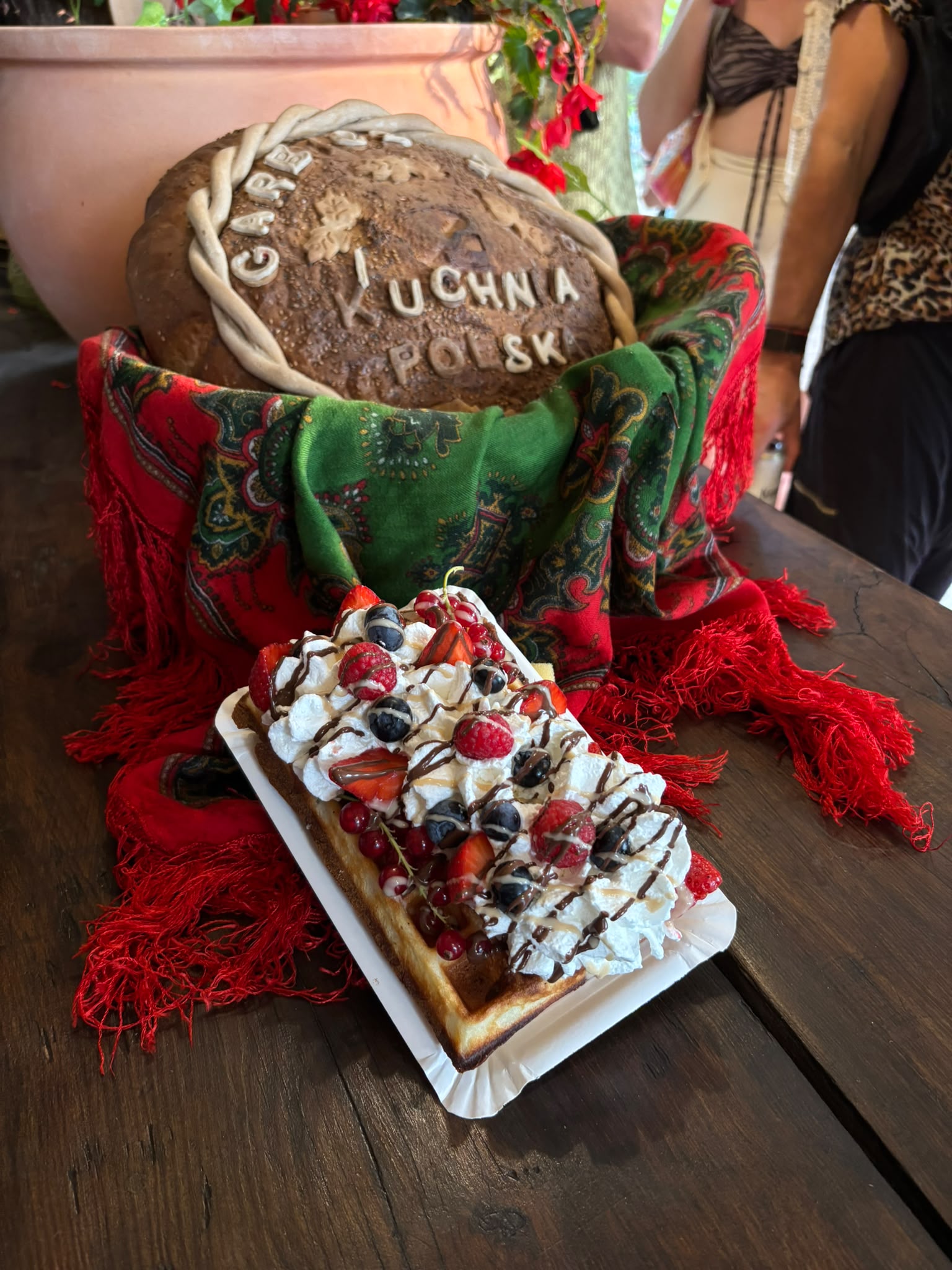 Waffle topped with whipped cream, berries and chocolate at Kuchnia Polska